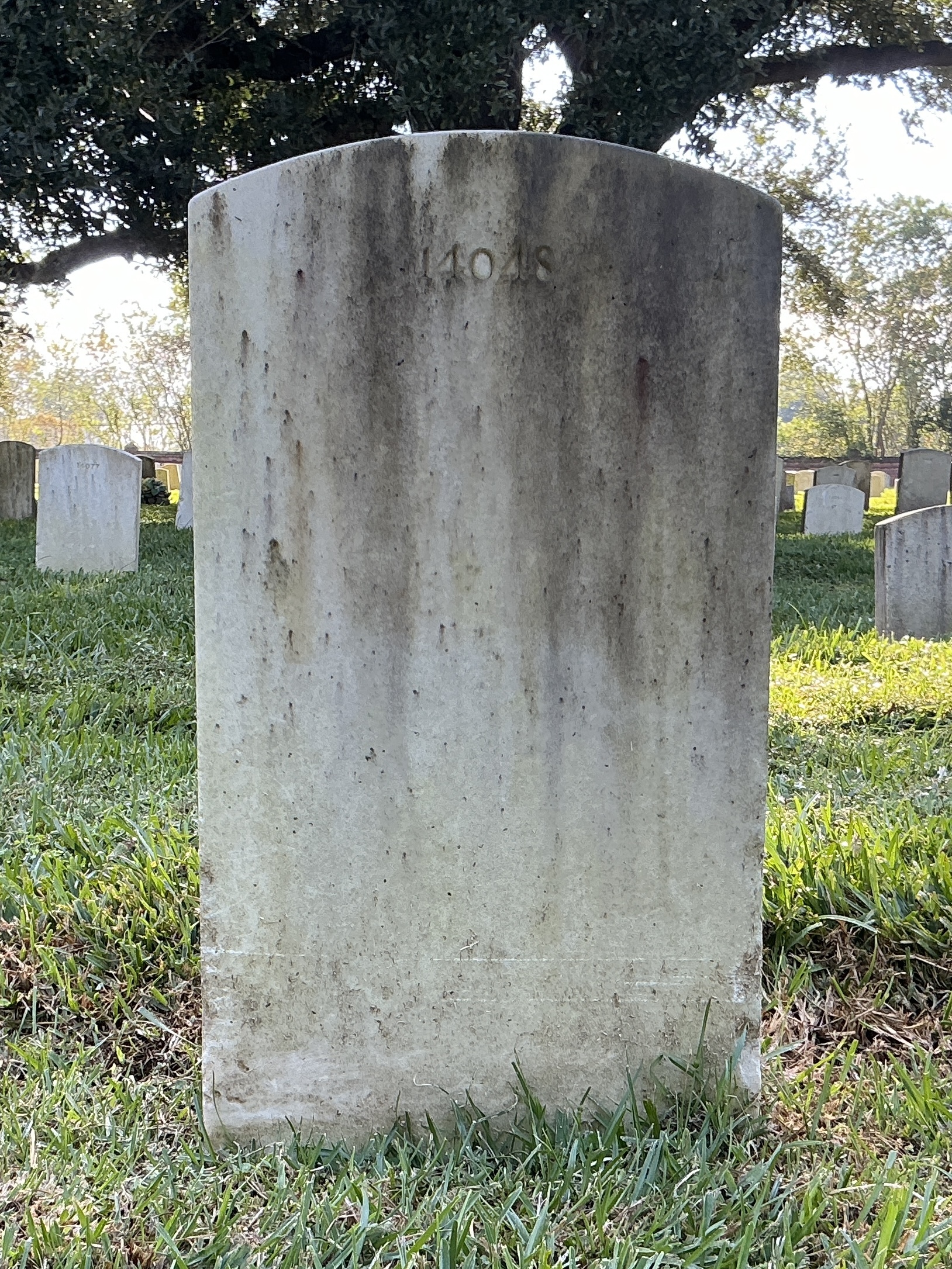 Back of upright marble headstone with flat face.