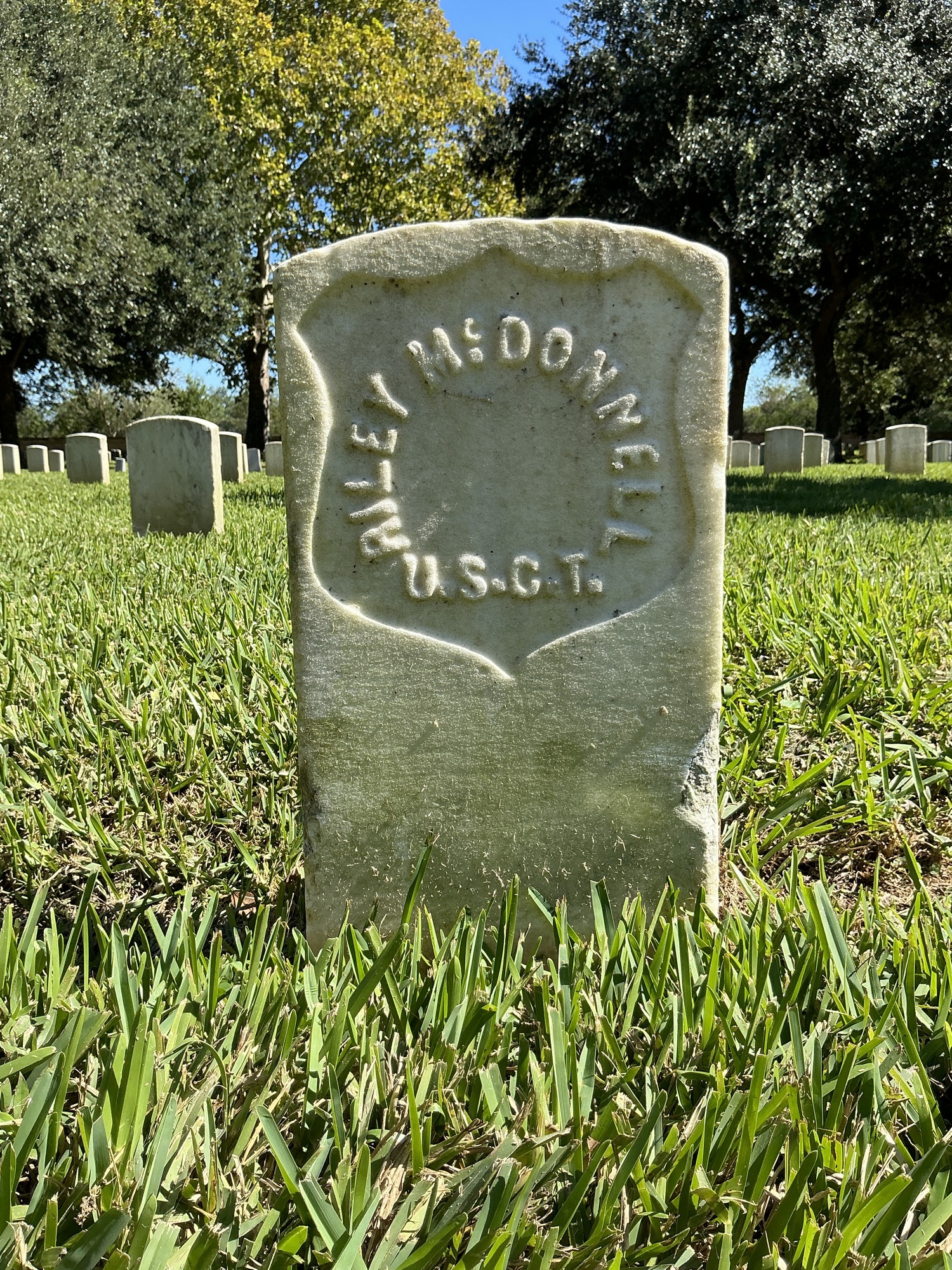Back of historic upright marble headstone with recessed shield face.