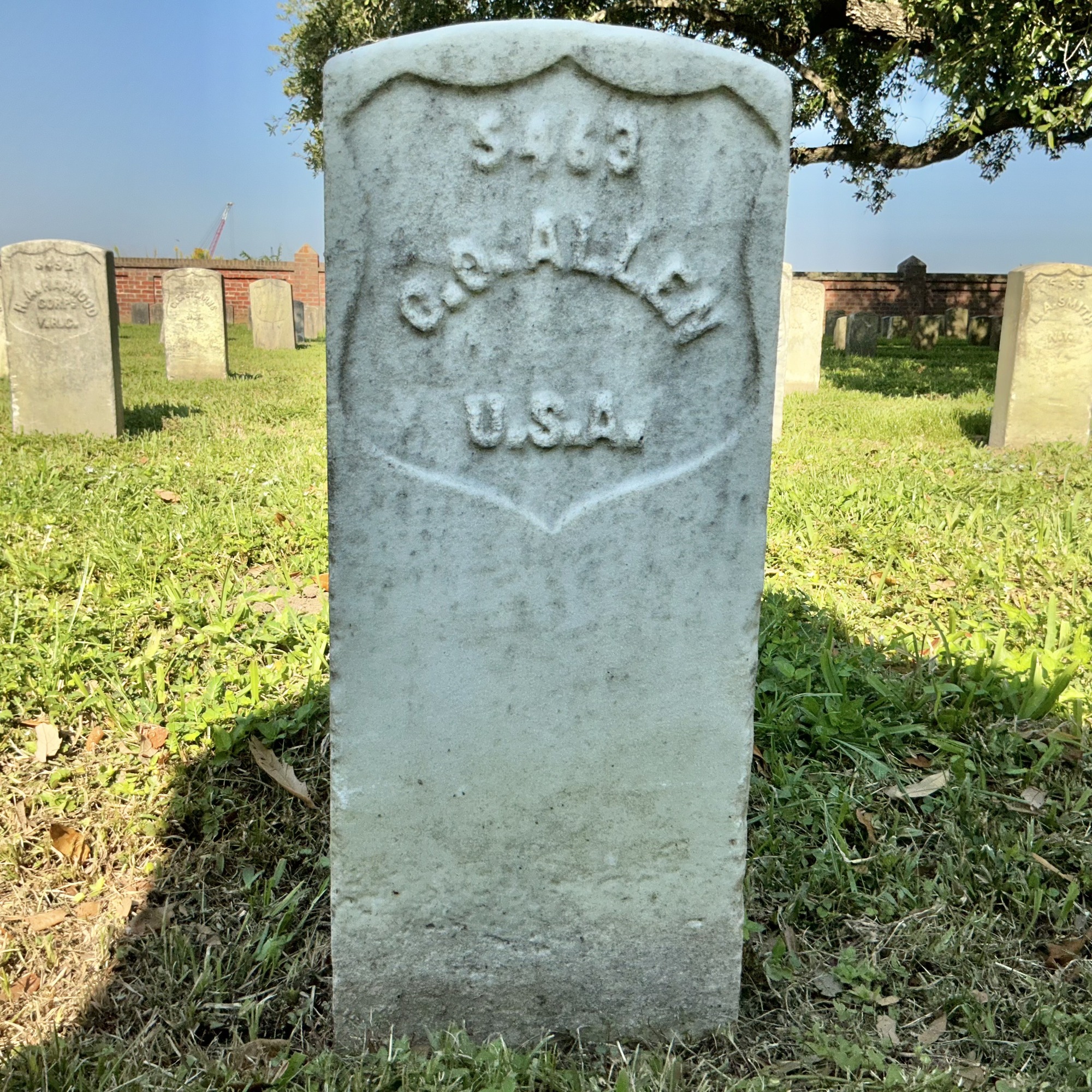 Front of historic upright marble headstone with recessed shield face.