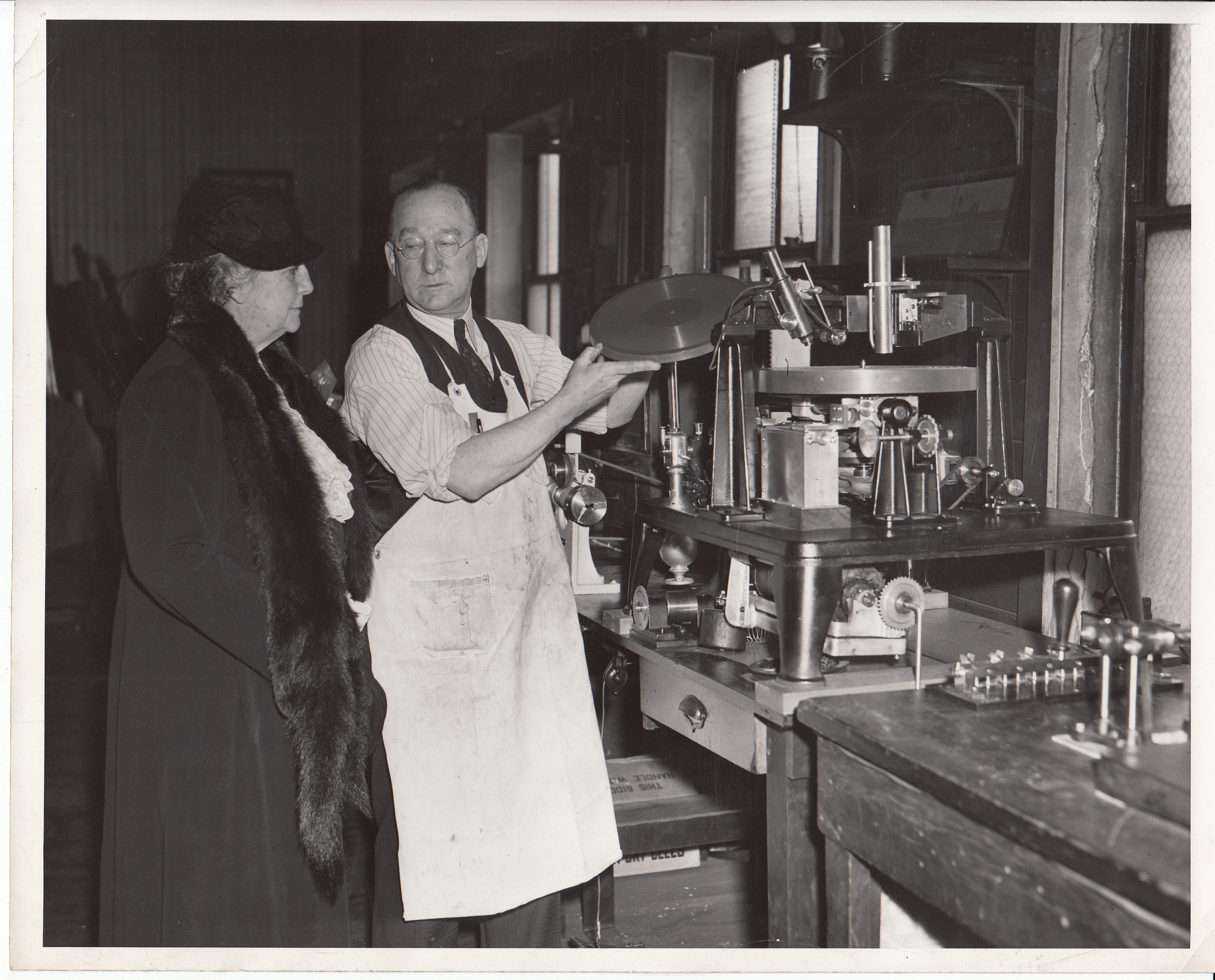 Mina Edison and William Hayes examining disc record-making machine [in Building 5 or Phonograph Works building?].