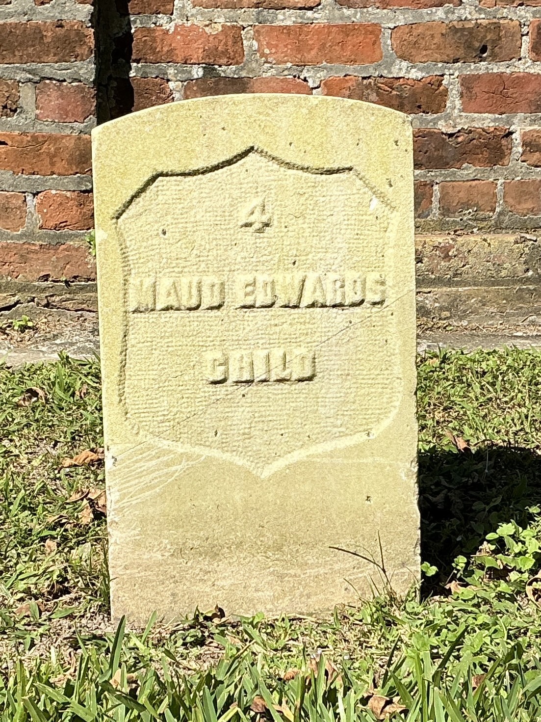 Front of historic upright marble headstone with recessed shield face.