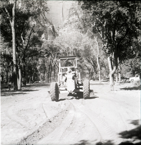 Tractor performing road work/construction for The Grotto parking area.
