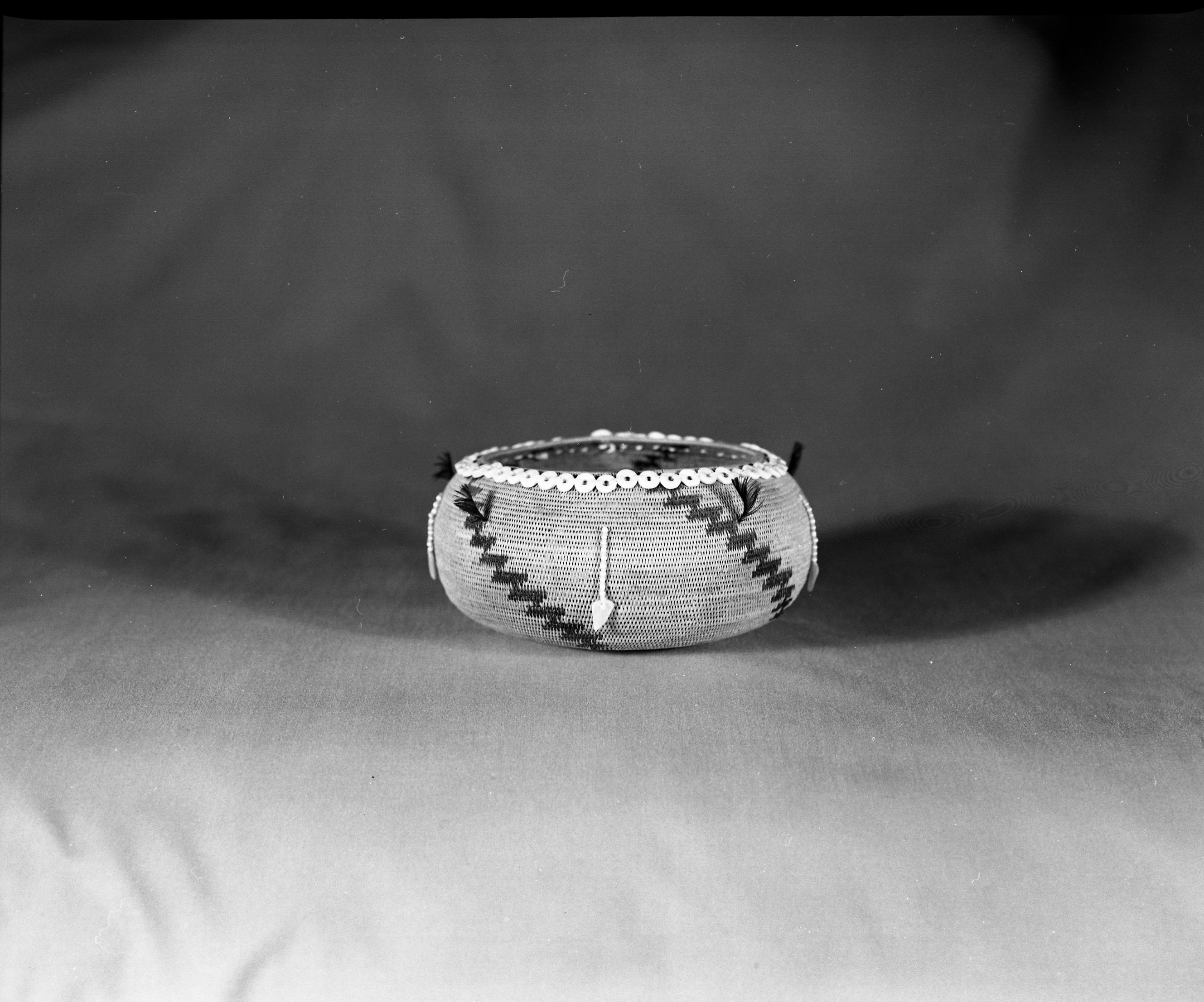 Private Collection, Catalog No. ---. Object: Pomo basket. Dimensions: 6 x 3". Materials: Sedge root, redbud, clam disc beads, glass beads, abalone pendants, and quail topknots. Technology: Single rod, interlocking stitch, c. 24 stitches to the inch. Collection History: None. Decorations possibly spurious. Photographed by Michael Dixon. Catalogued by Craig Bates and Barbara Beroza. Yosemite Collections, National Park Service.