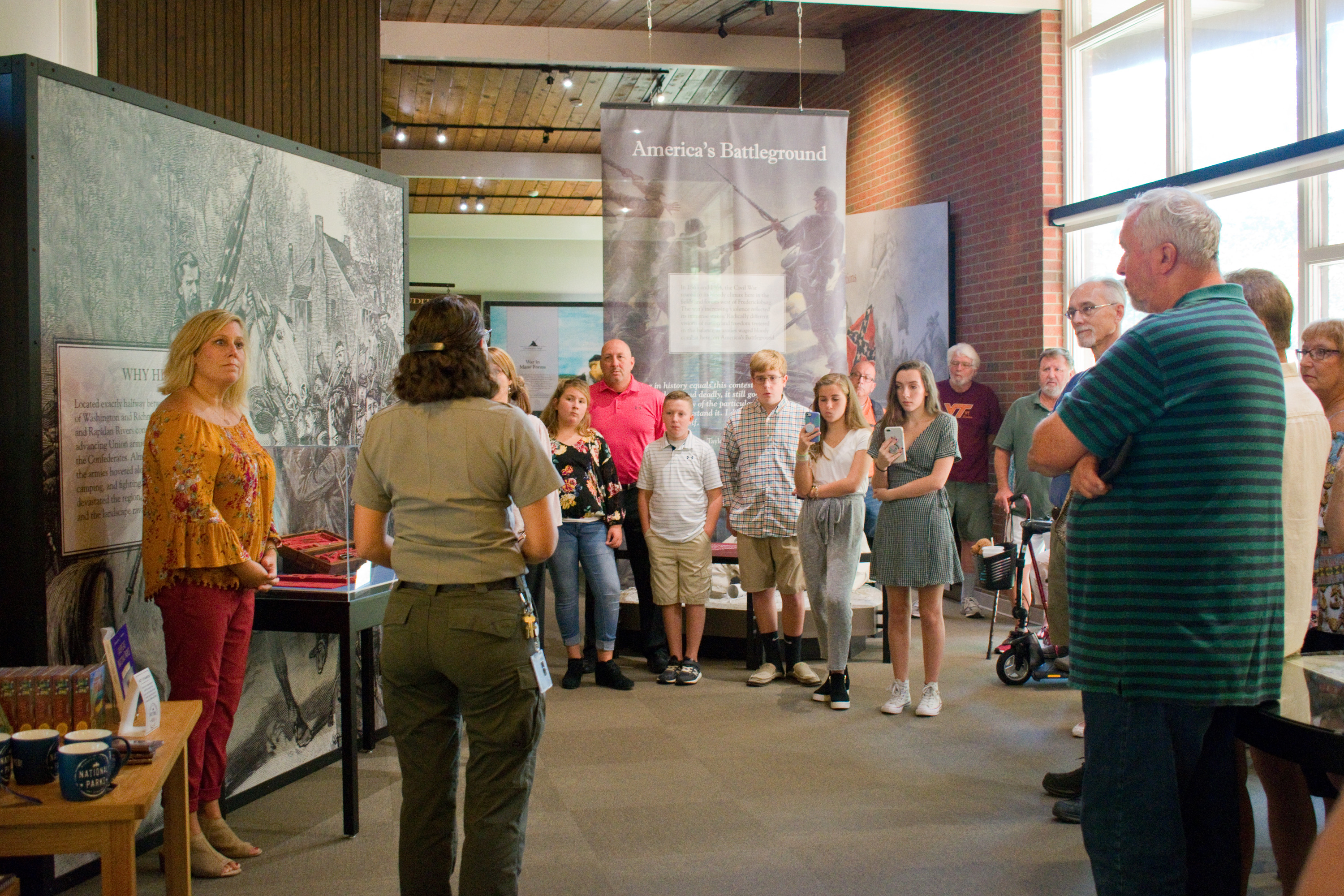 A Park Ranger speaking in front of a group of people in a visitor center.