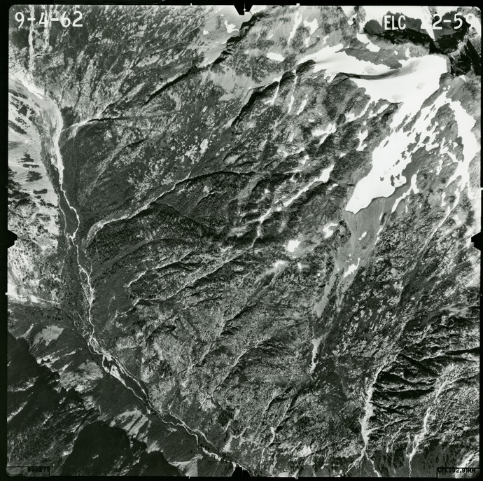 Black and white aerial photograph of glaciated mountain peaks and valleys.