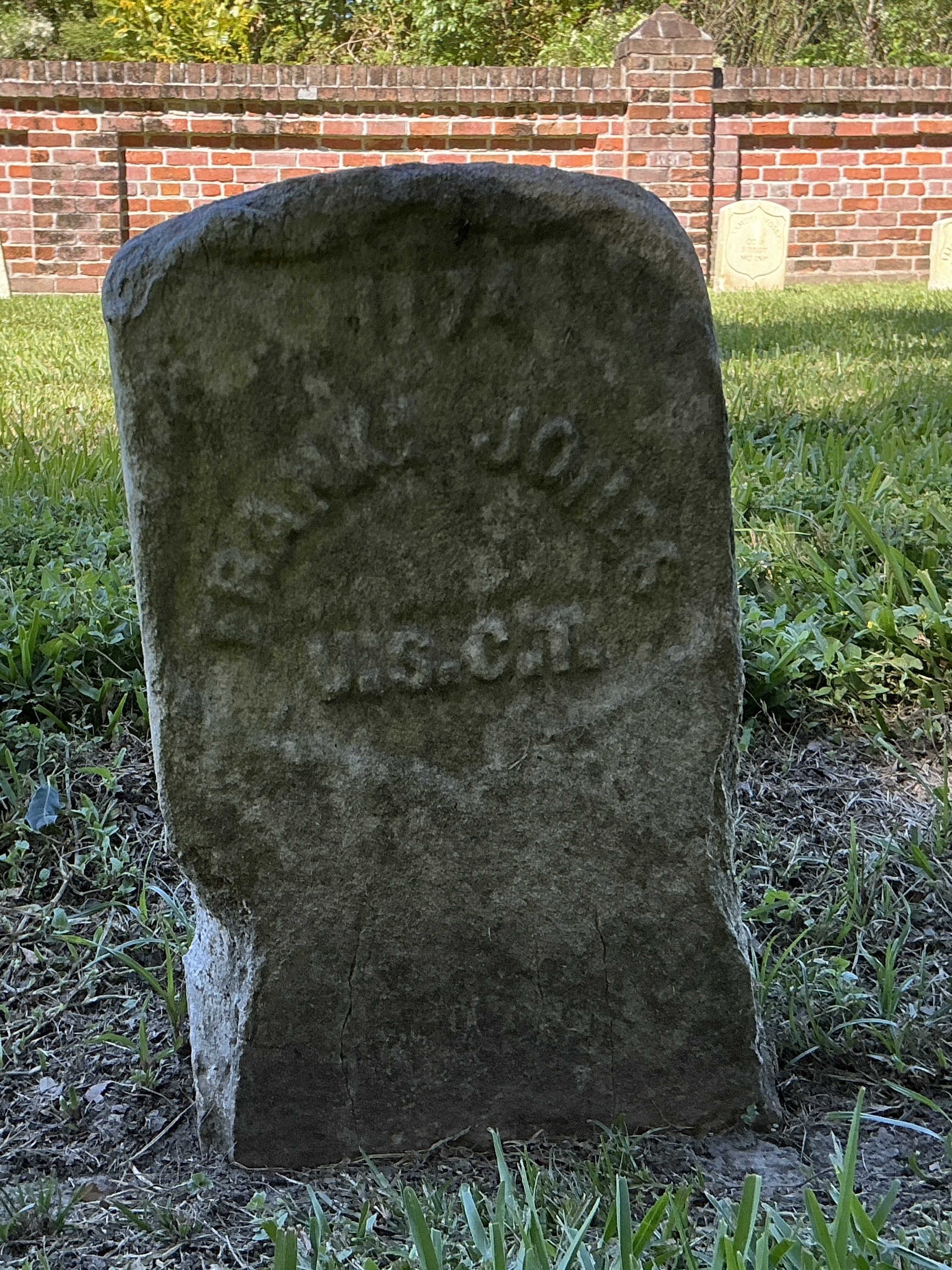 Front of historic upright marble headstone with recessed shield face.