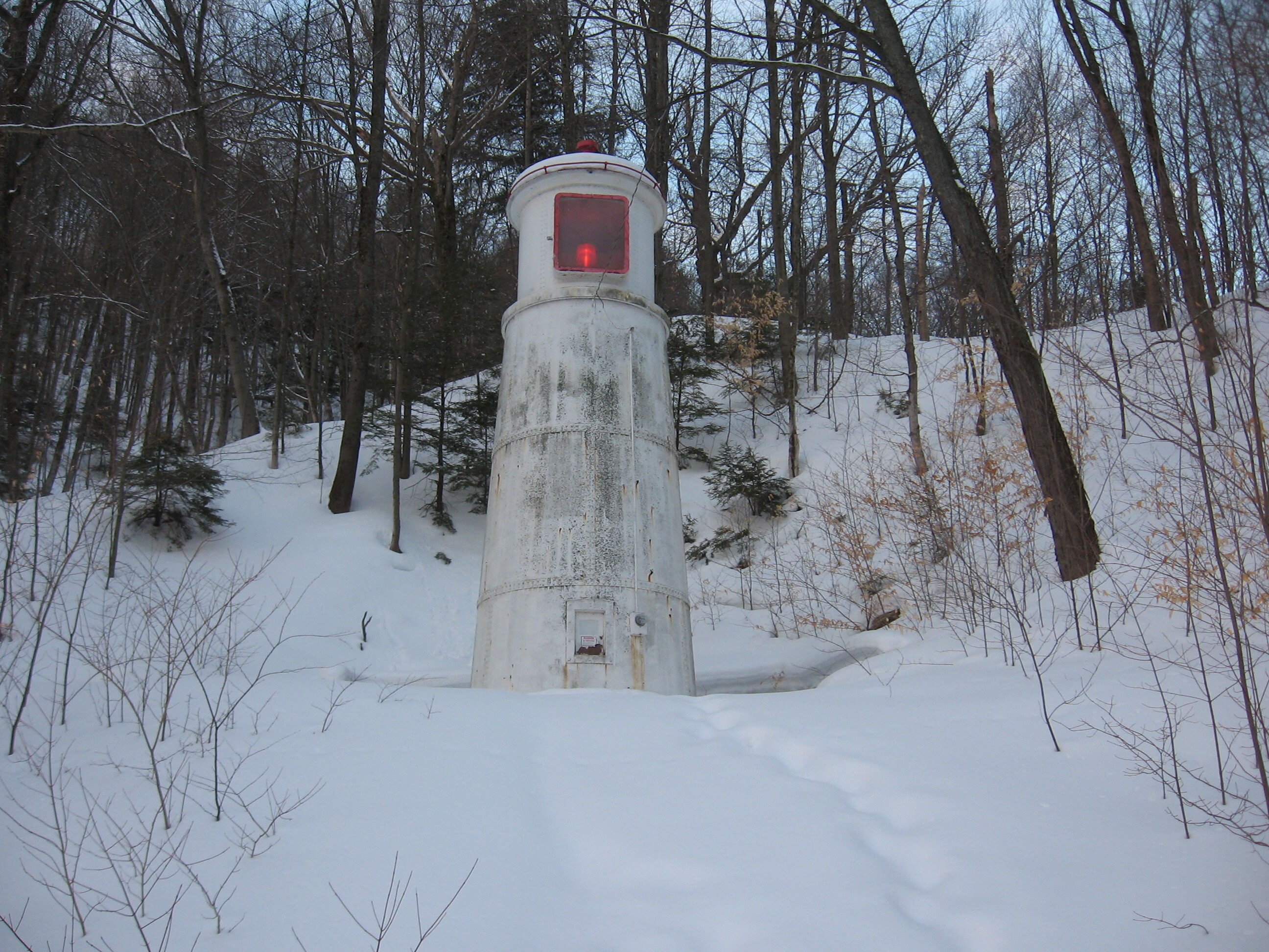Small lighthouse in the snowy woods.