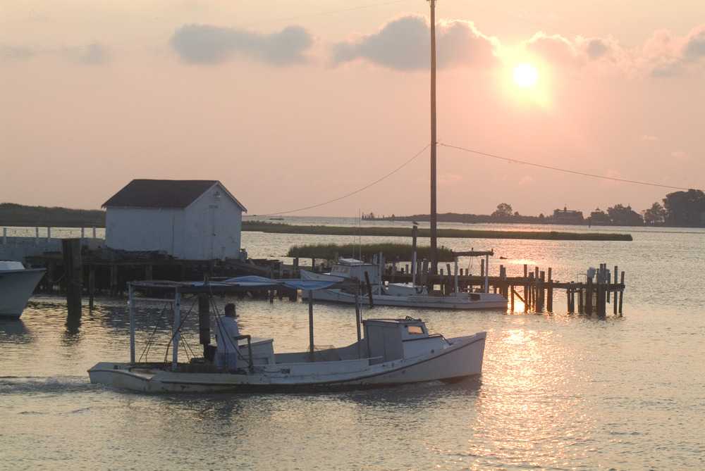 A boat in the foreground of a sunset