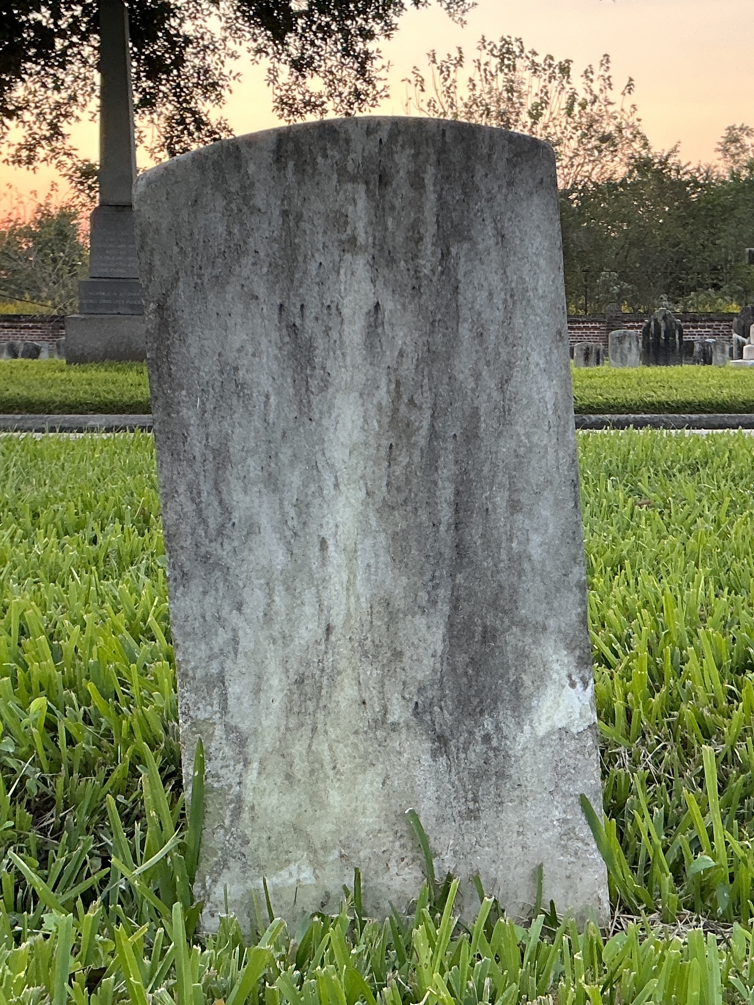 Back of historic upright marble headstone with recessed shield face.