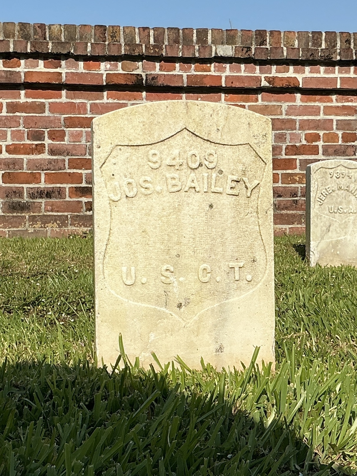 Front of historic upright marble headstone with recessed shield face.