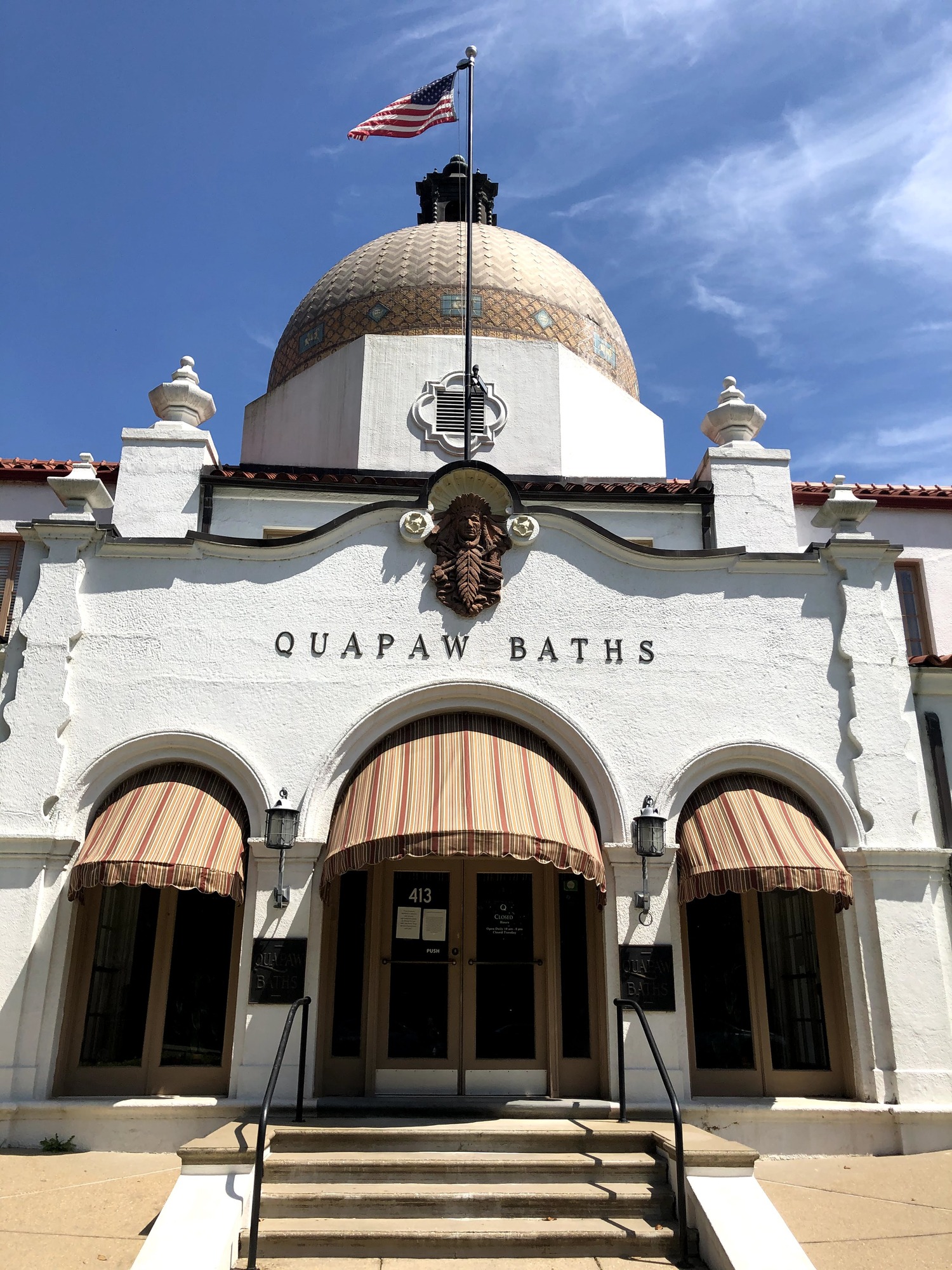 Front view of the Quapaw. Spanish style architecture with arched entry ways, an Indian motif, and a large tiled domed roof.