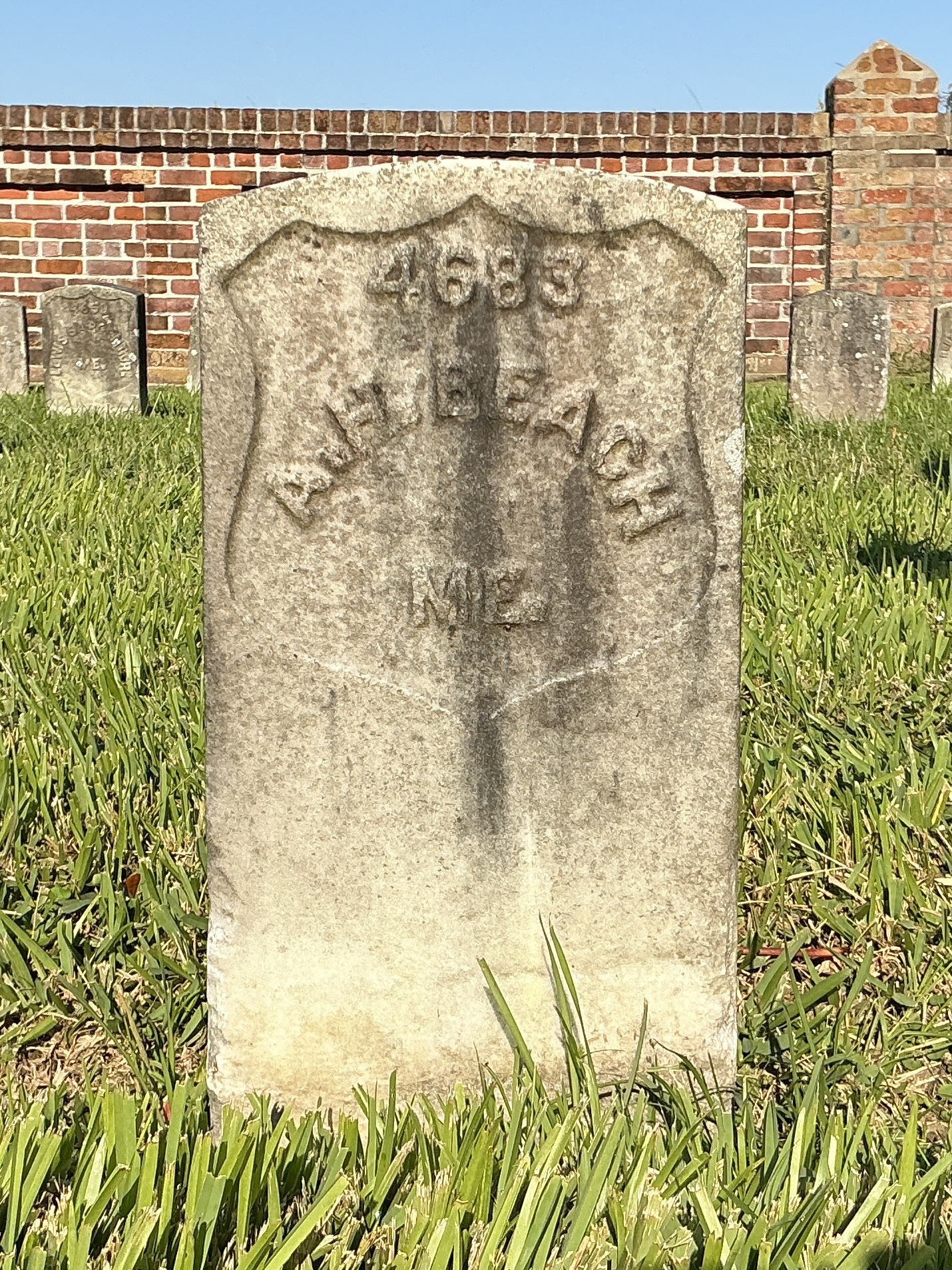 Front of historic upright marble headstone with recessed shield face.