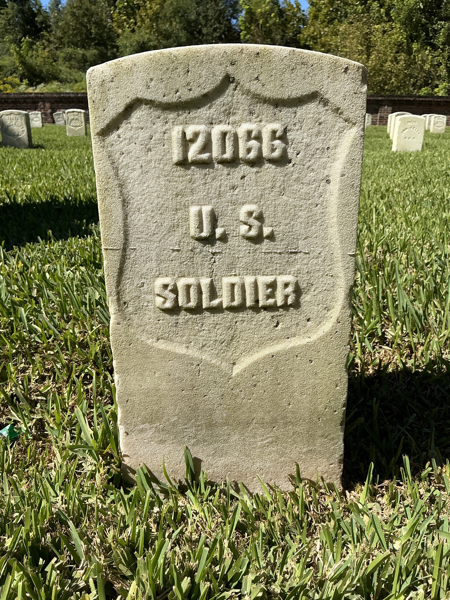 Front of historic upright marble headstone with recessed shield face.