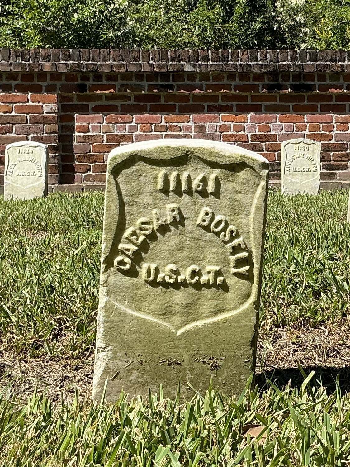 Front of historic upright marble headstone with recessed shield face.