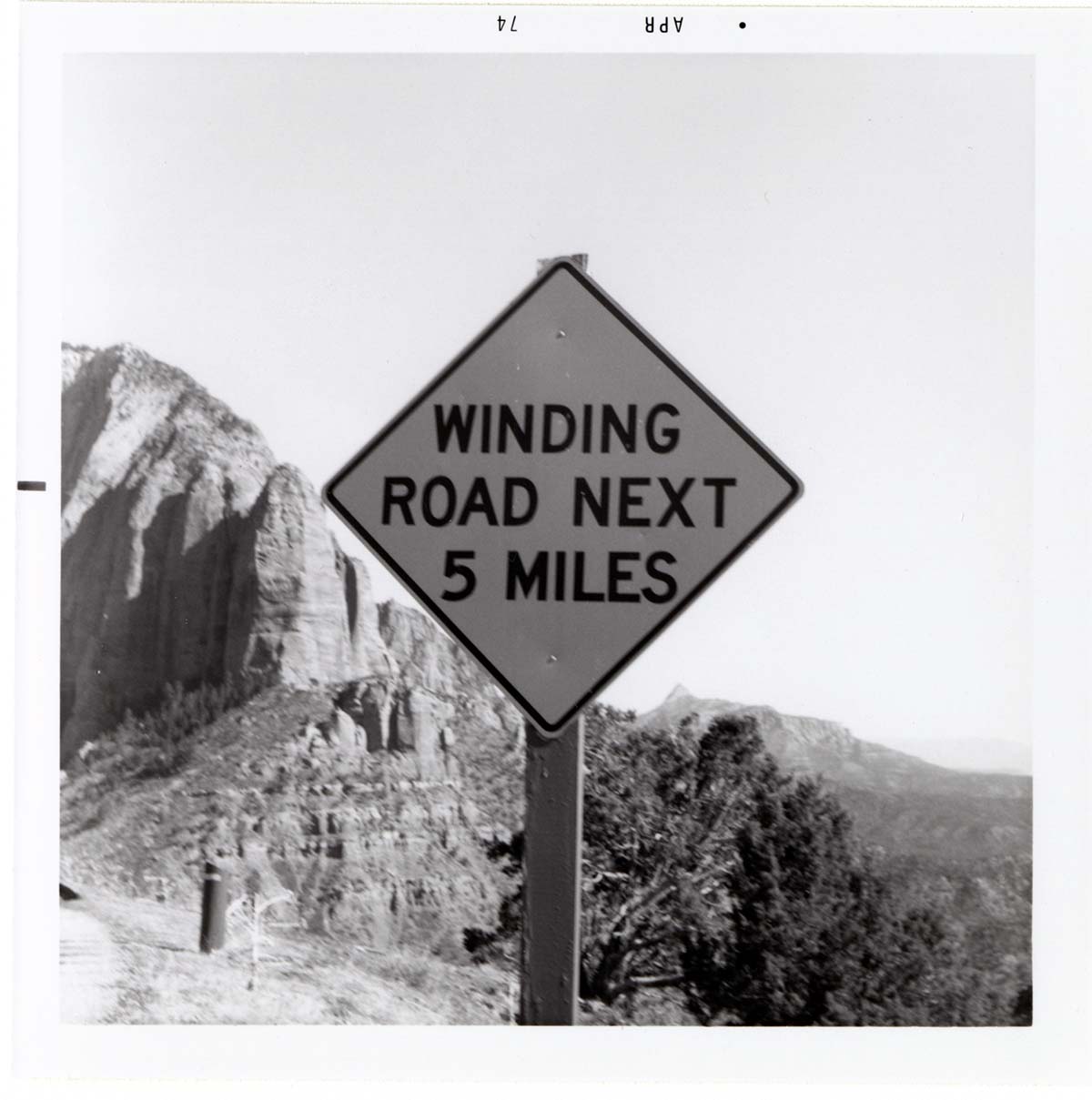 Road sign reading 'Winding Road Next 5 Miles' in Kolob Canyon.