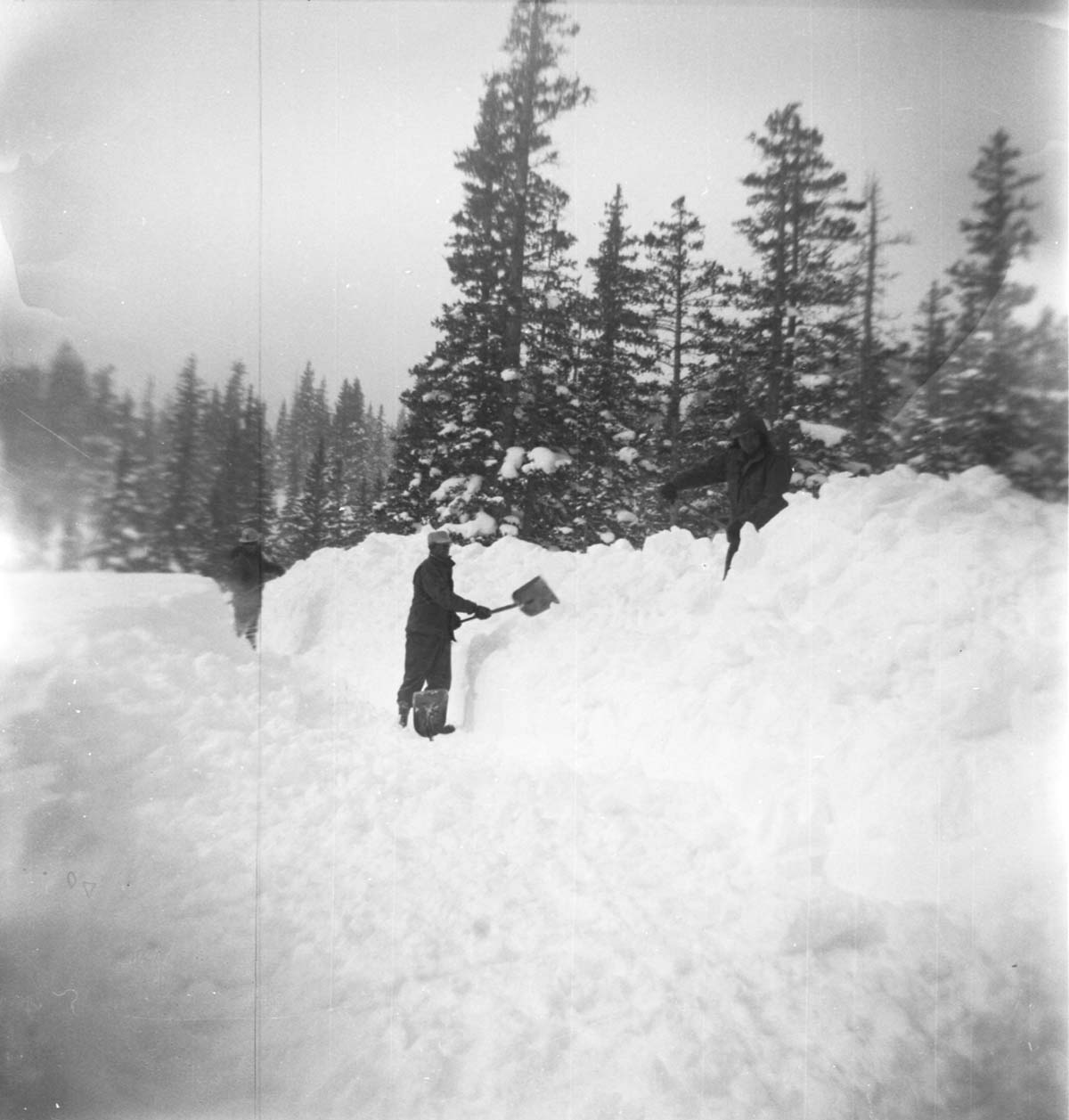 BW Photos showing rangers digging out the visitor center from snowdrift.