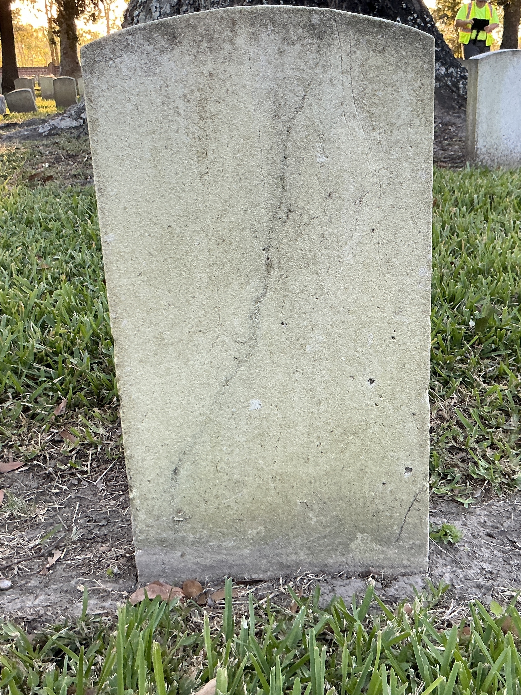Back of historic upright marble headstone with recessed shield face.