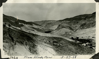 This is an historic black and white photograph from the Scotty's Castle Historic Photograph Collection, Death Valley National Park of Upper Grapevine Ranch from Windy Point looking east up Grapevine Canyon. Scotty's Castle Stables under construction. May 27, 1928. Photographed by Mat Roy Thompson.