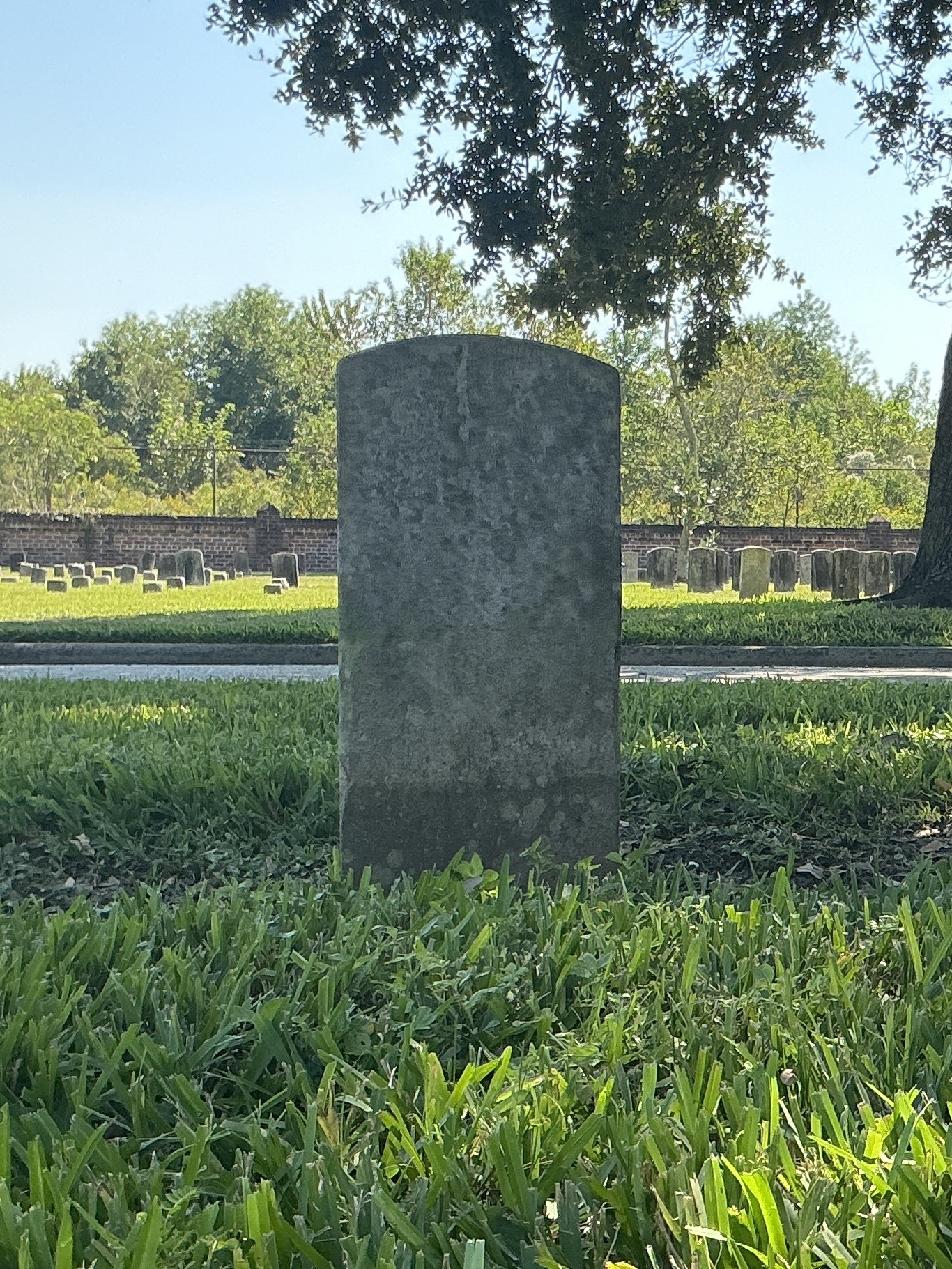Back of historic upright marble headstone with recessed shield face.