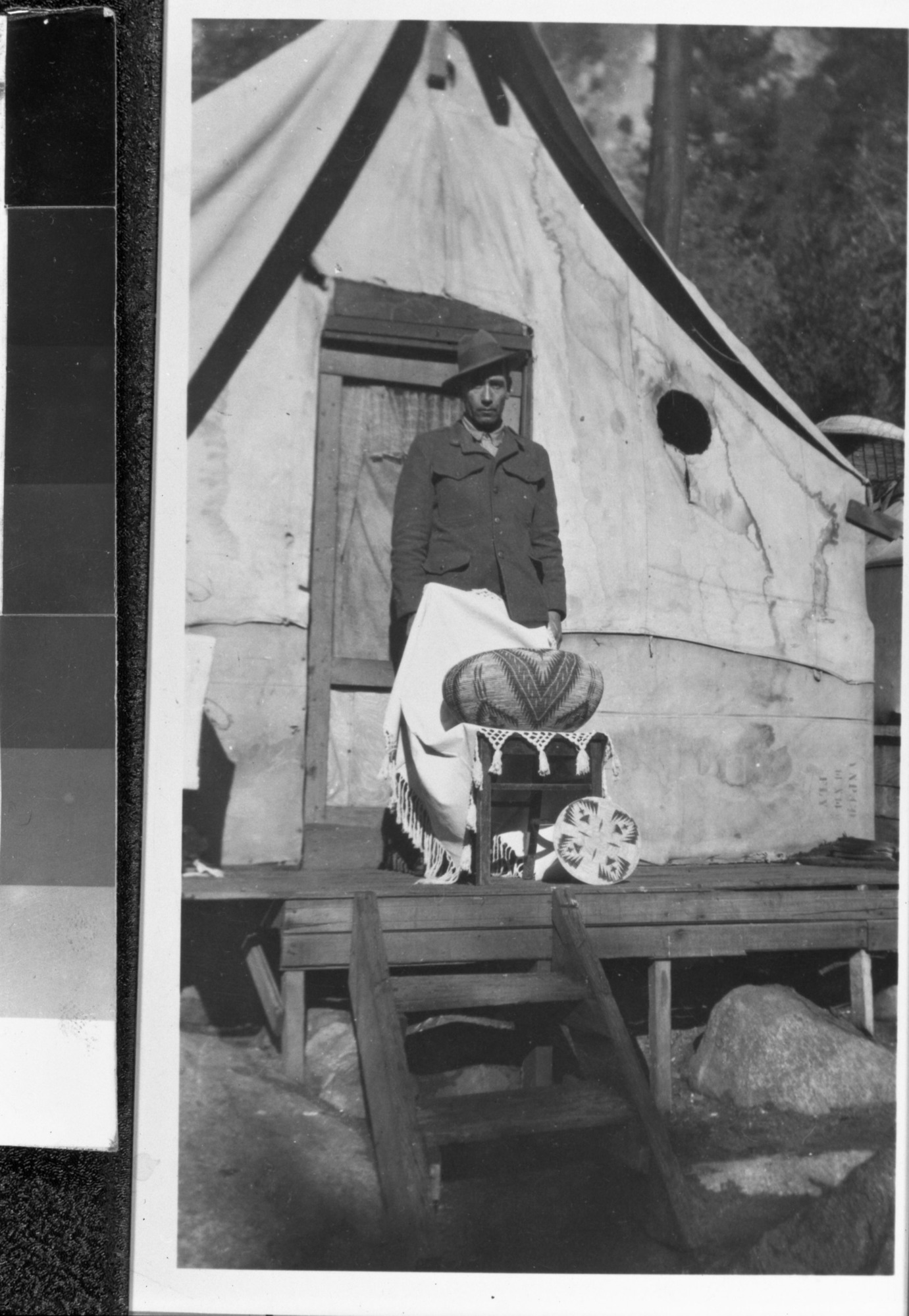 John Telles with his wife Lucy's large basket at the Old Indian Village in Yosemite Valley. James H. Schwabacher, Jr. collection.