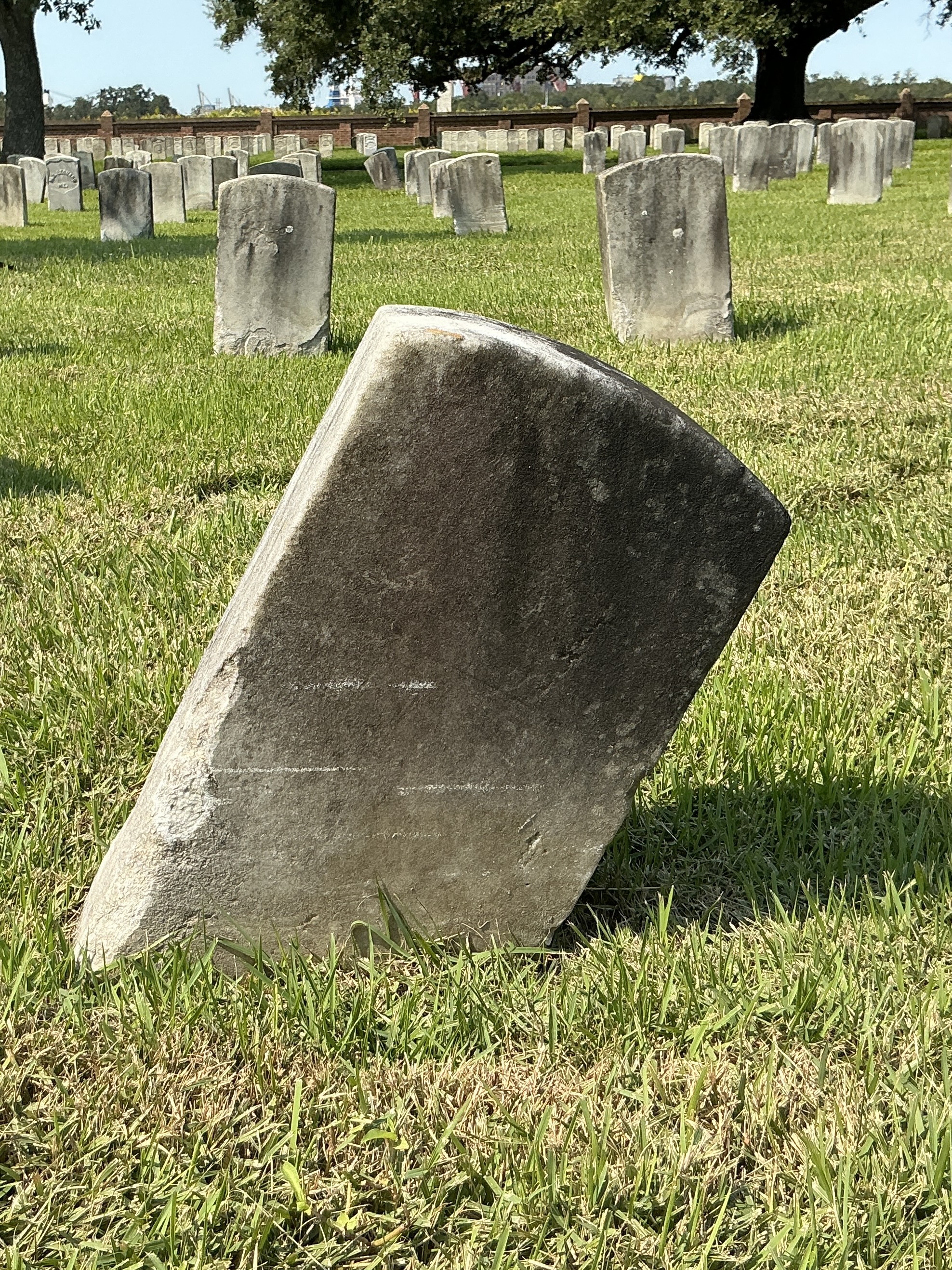 Back of historic upright marble headstone with recessed shield face.