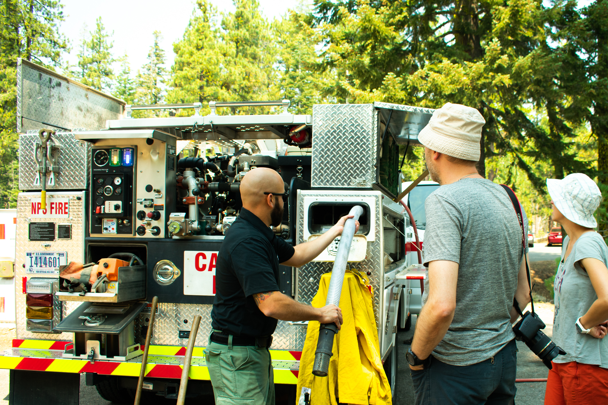 A firefighter pulls a hose from a fire engine to show visitors at the 2018 Day in the Park event.