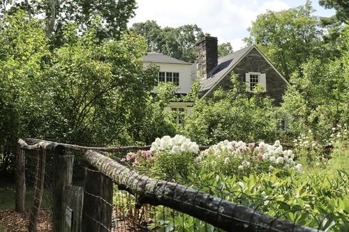 Garden partially blocking a historic home behind it 