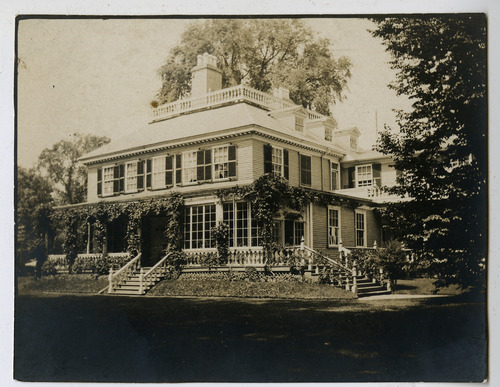 Black and white photograph of Georgian mansion with enclosed porch.