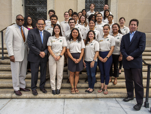 A group stands on the steps of the Department of the Interior building.