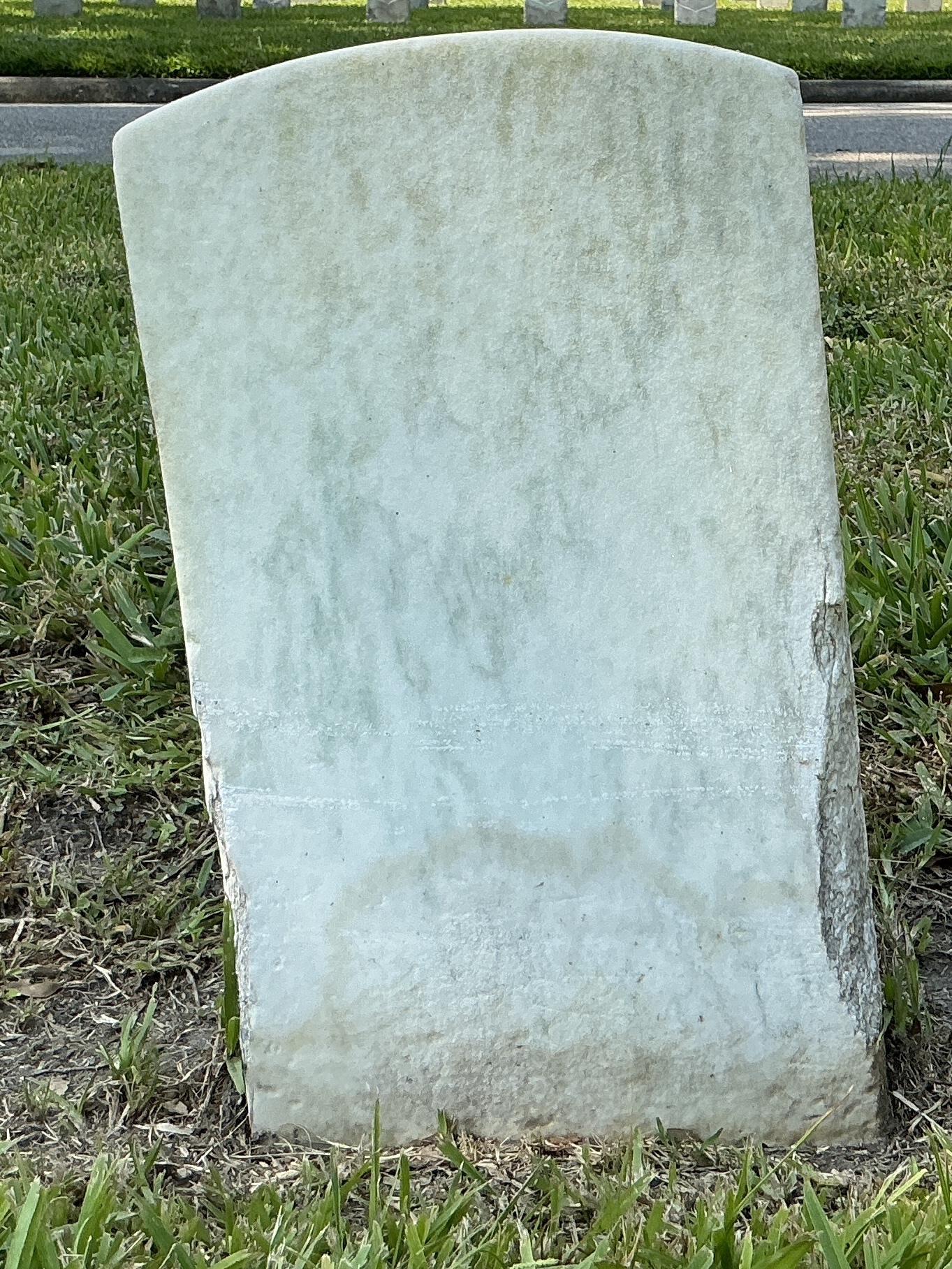 Back of historic upright marble headstone with recessed shield face.
