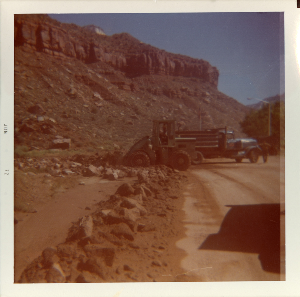 Construction vehicles working on road at the south entrance to the park.