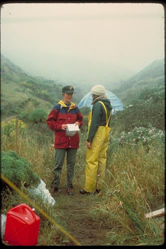 Park ranger talking to a camper in a foggy canyon.