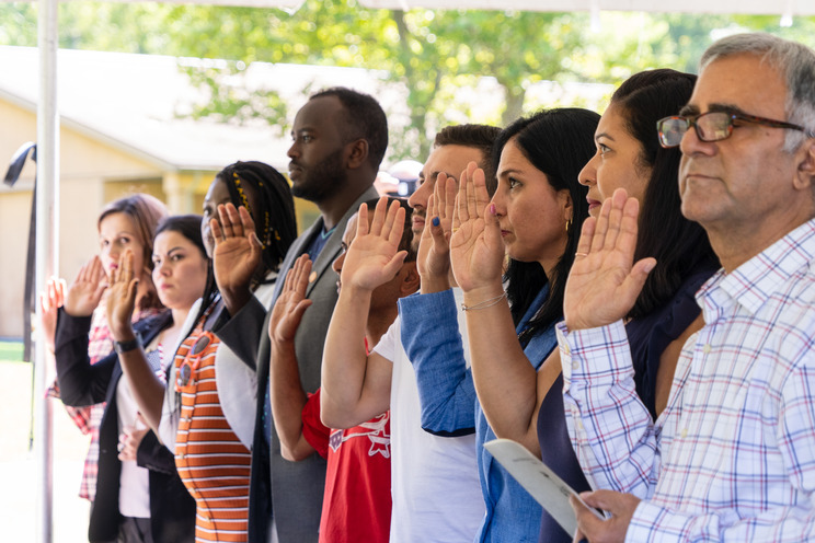 People take an oath under a tent.