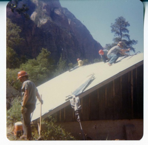 Workers working on the reroofing of the Birch Creek Horse Barn.