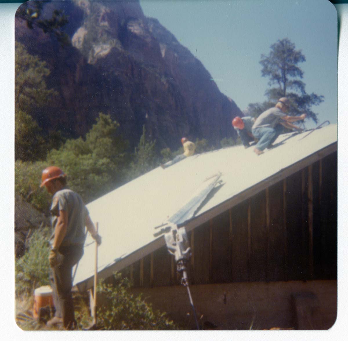 Workers working on the reroofing of the Birch Creek Horse Barn.