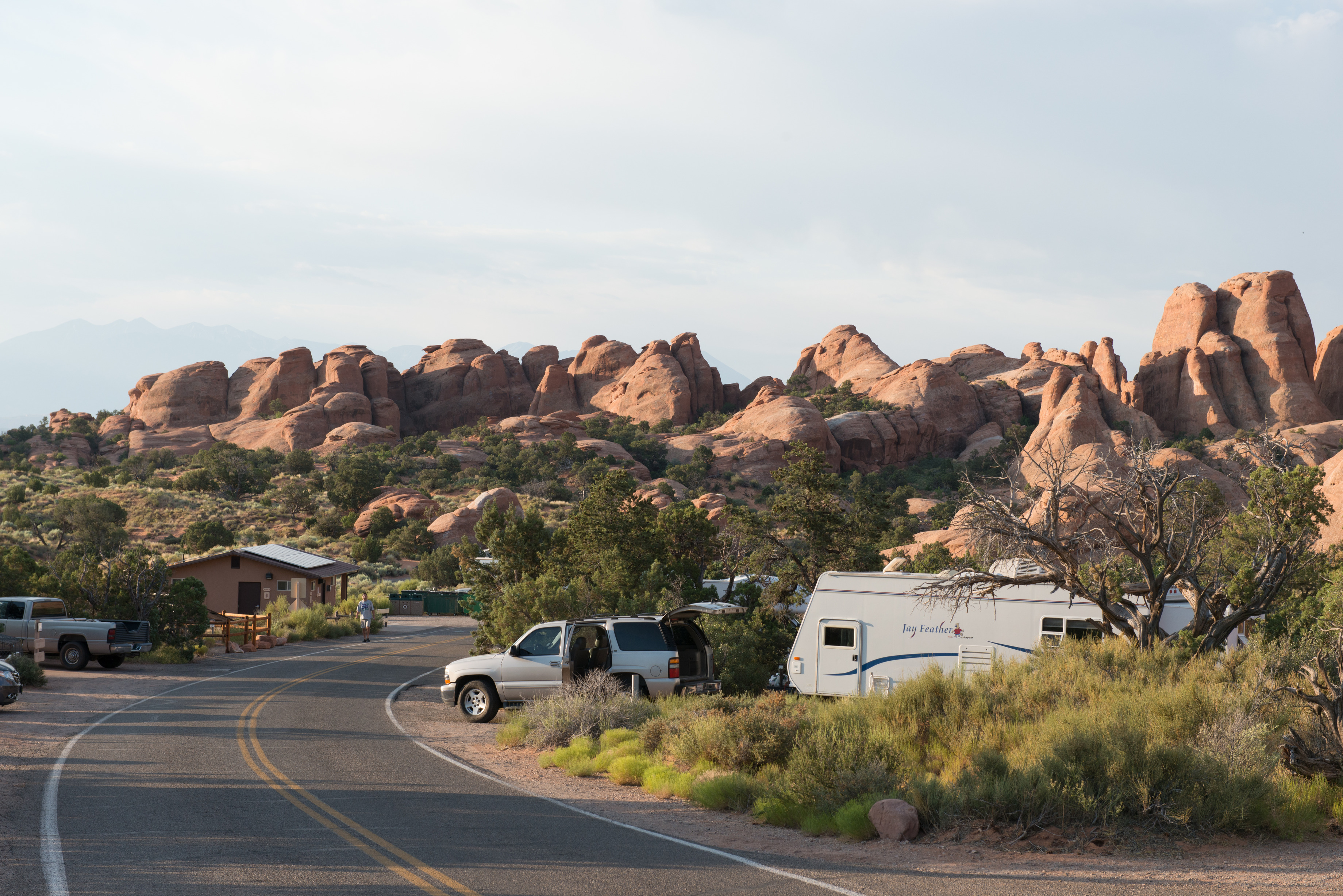campsites with vehicles in front of a wall of stone pinnacles