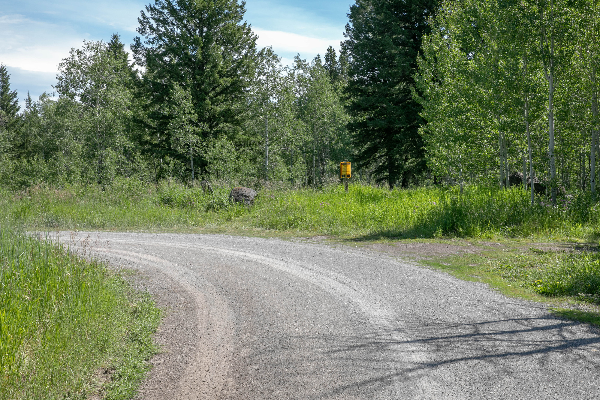 A road curves left right at the beginning of the trail.