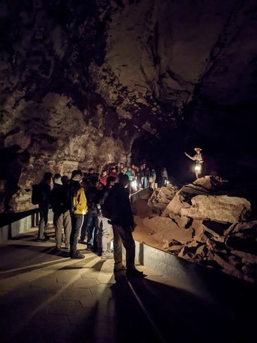 Group of people inside cave listening to park ranger.