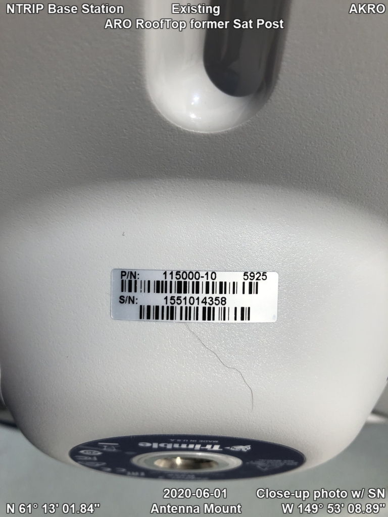 Existing NTRIP base station Trimble Zephyr antenna mount at AKRO on a rooftop/former satellite post with close-up of serial number.