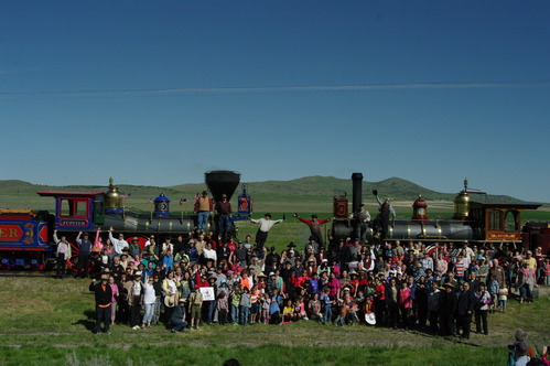 Visitors pose in front of the two locomotives. 