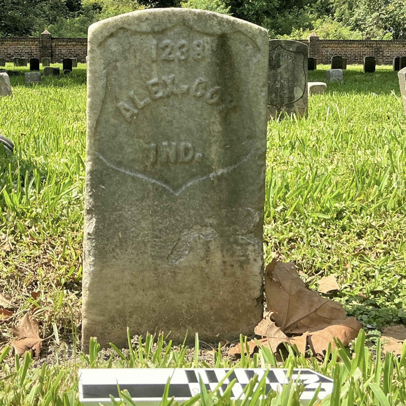 Extra image of historic upright marble headstone with recessed shield face.