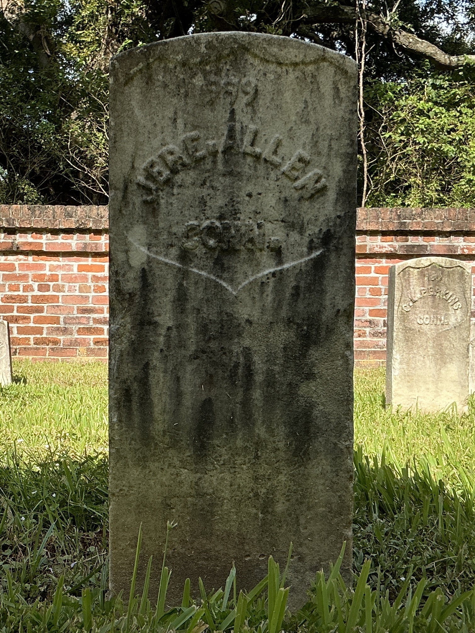 Front of historic upright marble headstone with recessed shield face.