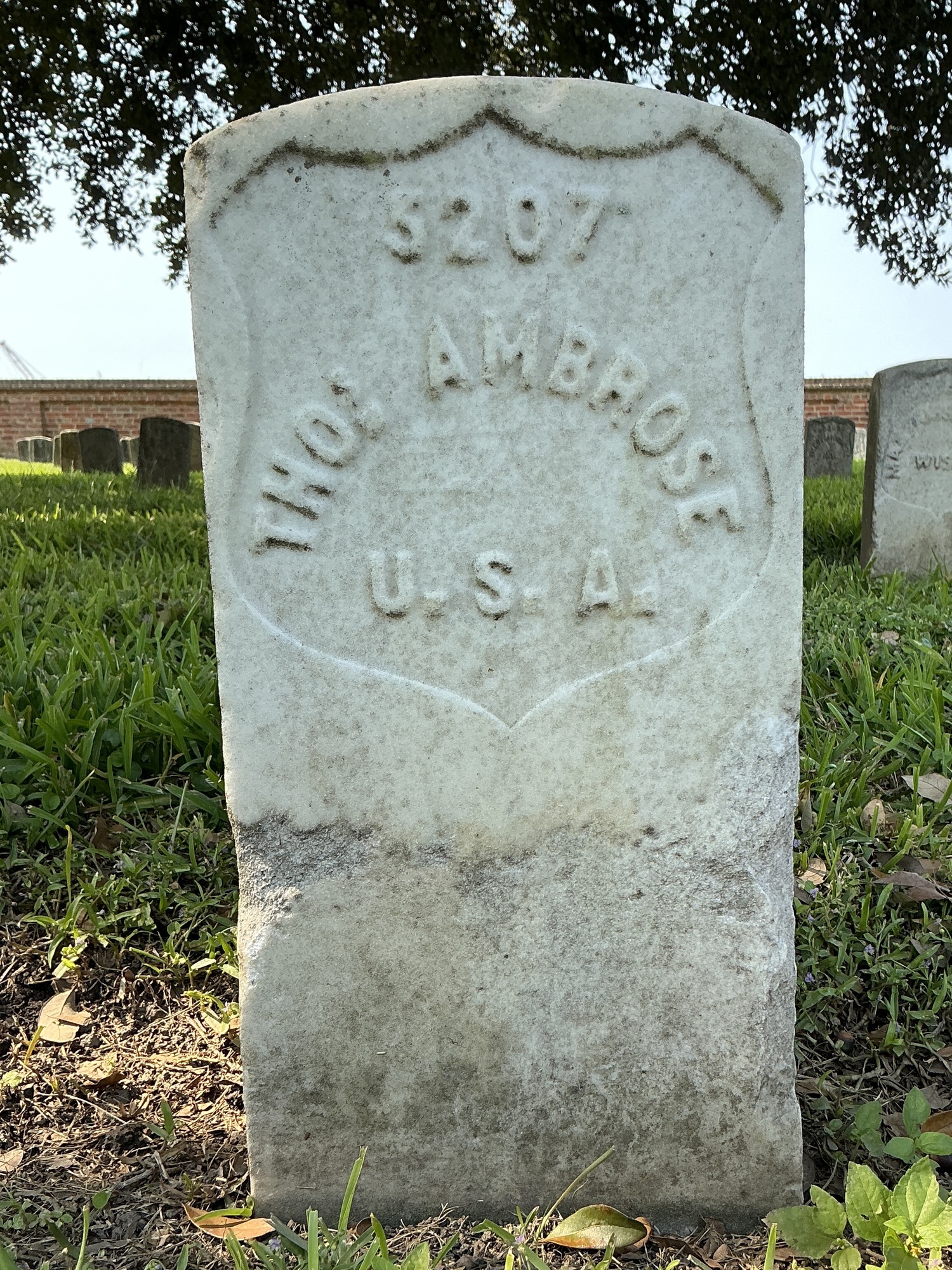 Front of historic upright marble headstone with recessed shield face.