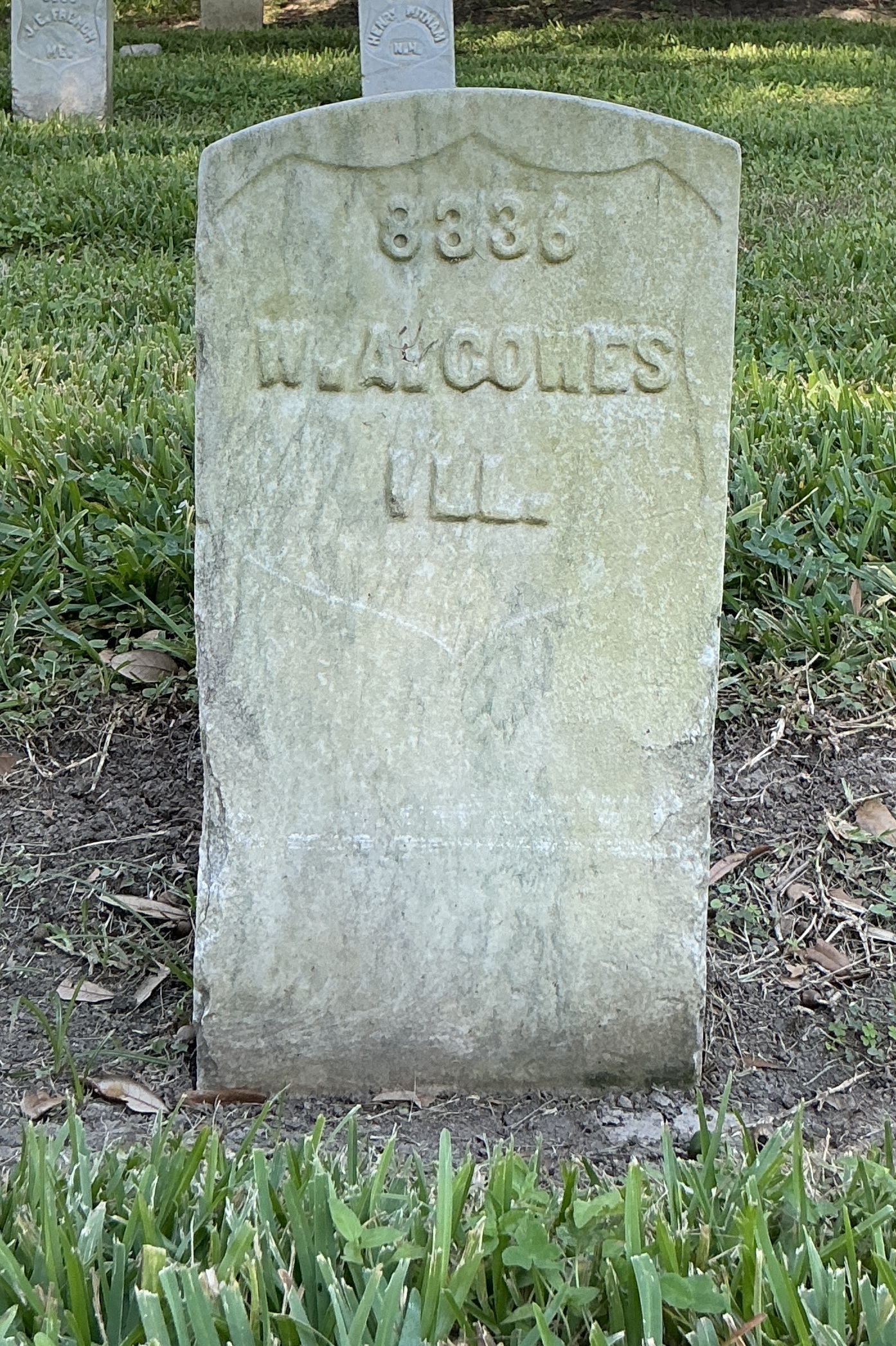 Front of historic upright marble headstone with recessed shield face.