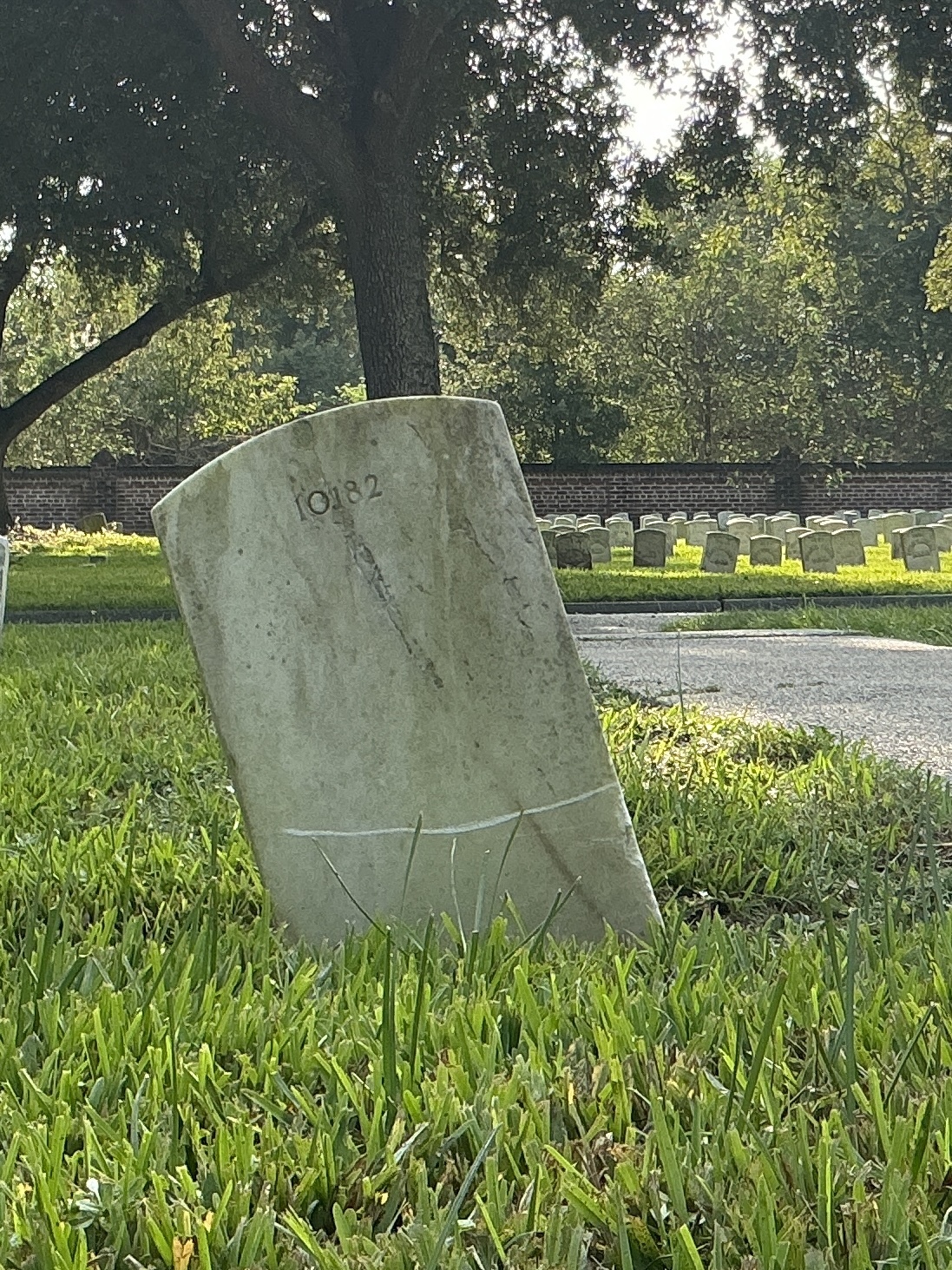 Back of historic upright marble headstone with recessed shield with recessed lettering face.