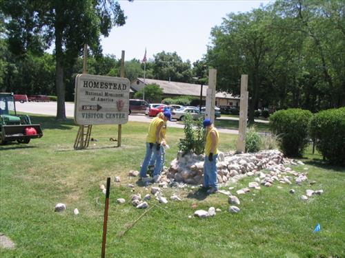 Three YCC workers working on old sign base demolition at HOME visitor center.