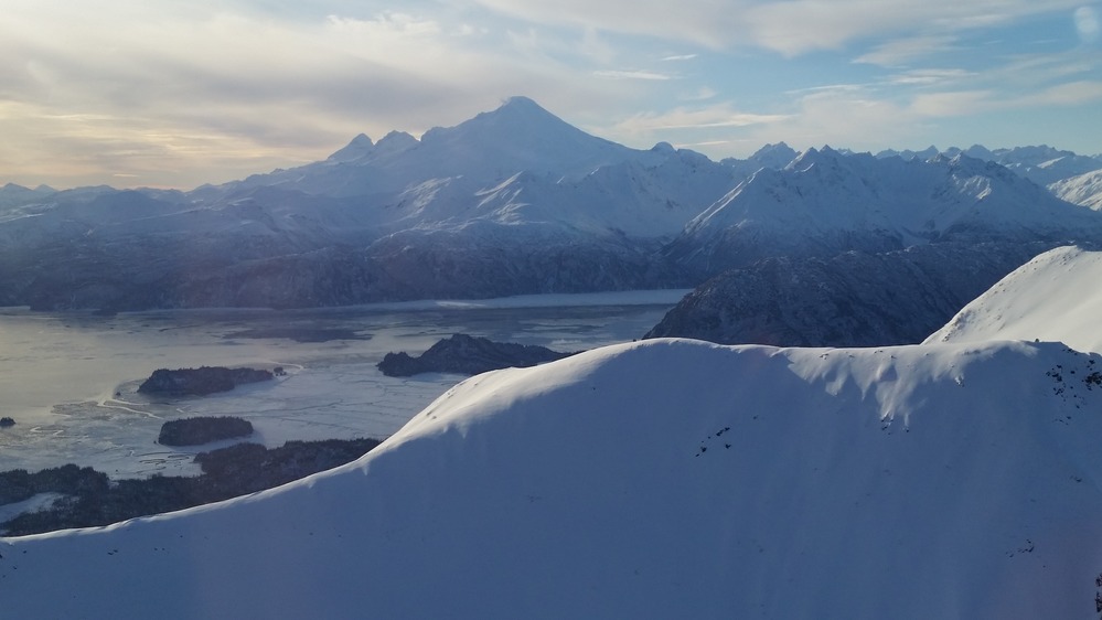 Iliamna Volcano rises from the coast during winter with snowy ridges in the foreground
