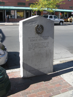 A stone monument on a sidewalk.