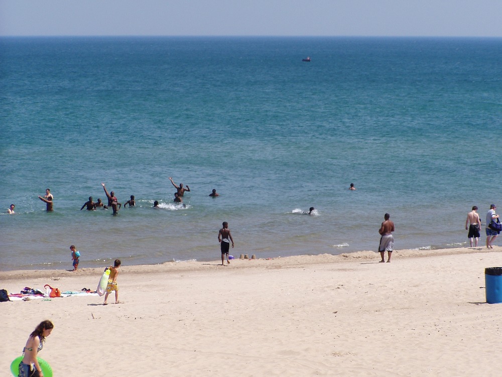 Family playing catch with a football at west beach.