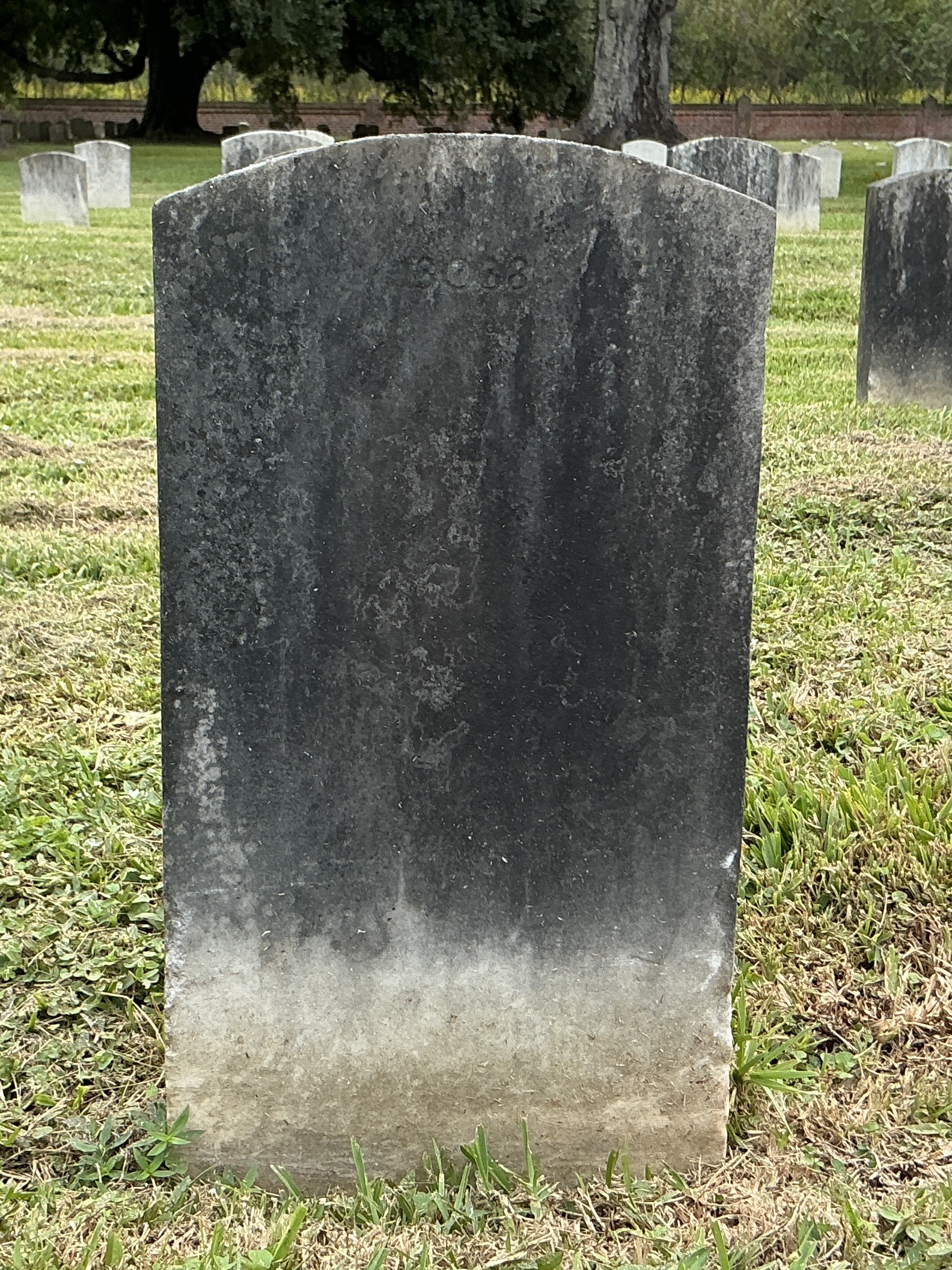 Back of upright marble headstone with flat face.
